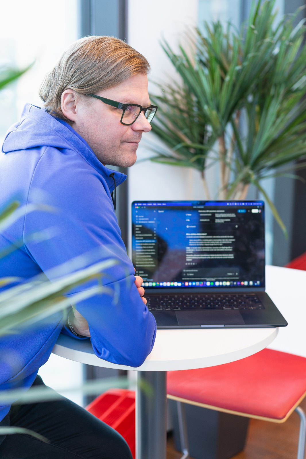 Räikeeläinen läppärin ääressä toimistossa, ruudulla avoinna työkalu